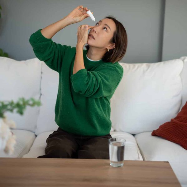 Woman applying eye drops for eye care and vision health